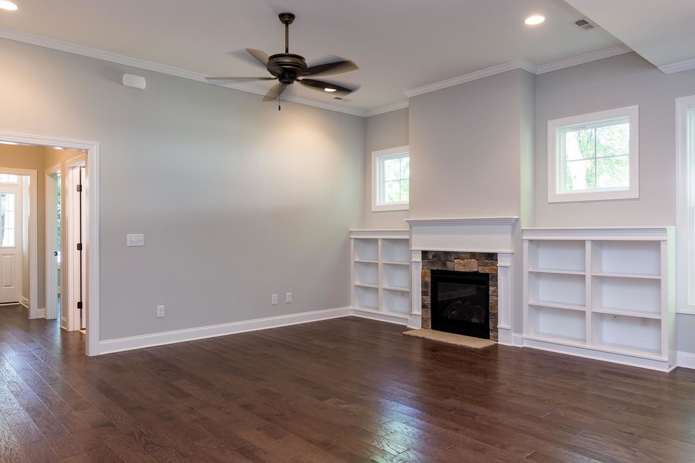 Inspiration for a medium sized classic open plan games room in Raleigh with grey walls, medium hardwood flooring, a standard fireplace and a stone fireplace surround.