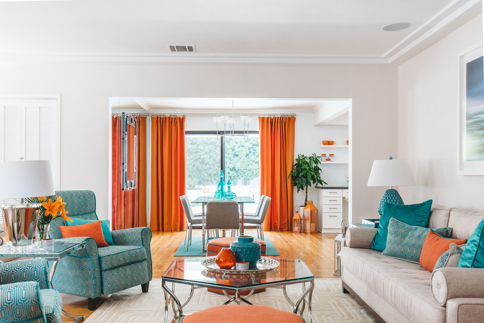 Example of an eclectic enclosed medium tone wood floor and orange floor game room design in Los Angeles with white walls