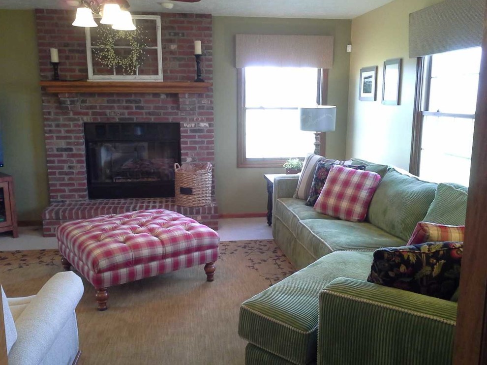 На фото: изолированная гостиная комната среднего размера в стиле кантри с зелеными стенами, ковровым покрытием, стандартным камином, фасадом камина из кирпича, телевизором в углу и бежевым полом