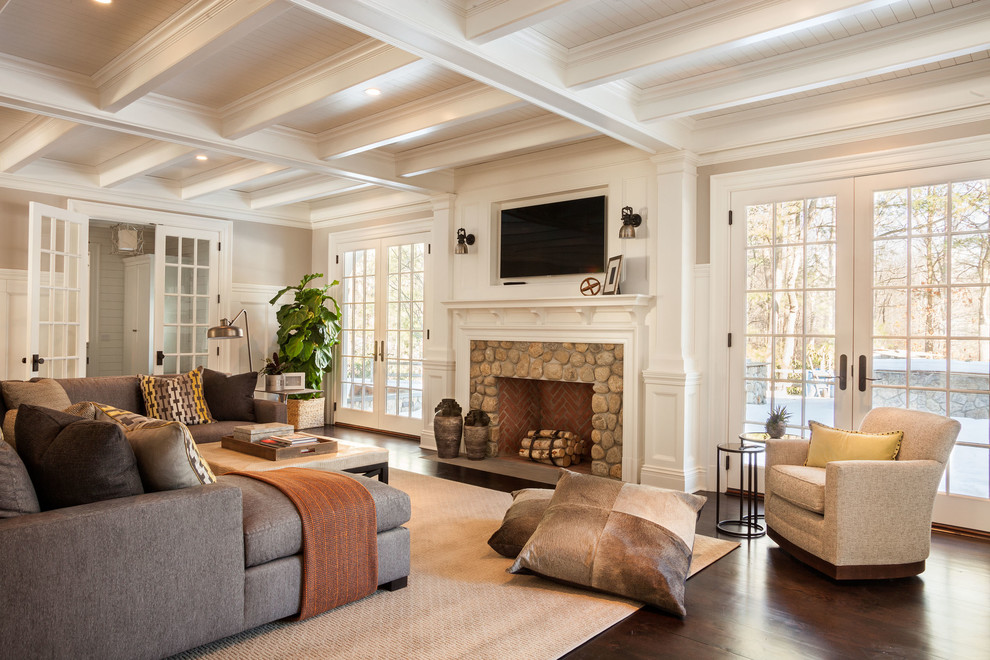 Mittelgroßes, Abgetrenntes Klassisches Wohnzimmer mit beiger Wandfarbe, dunklem Holzboden, Kamin, Kaminumrandung aus Stein und TV-Wand in New York