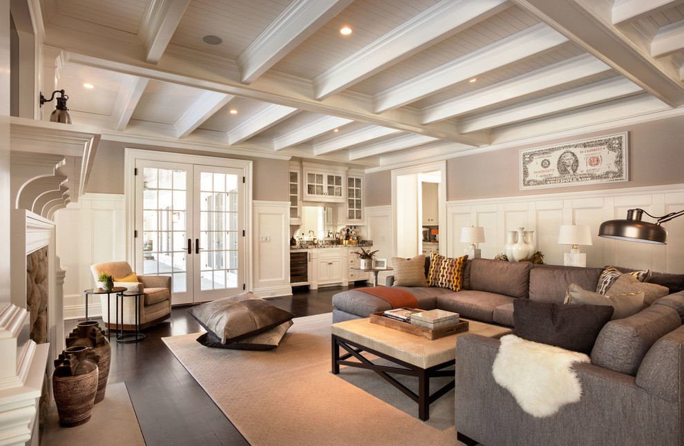 Mittelgroßes, Abgetrenntes Klassisches Wohnzimmer mit beiger Wandfarbe, dunklem Holzboden, Kamin, Kaminumrandung aus Stein und TV-Wand in New York