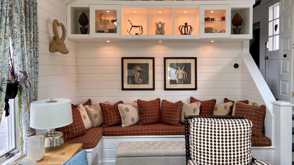 Imagen de sala de estar abierta y abovedada de estilo de casa de campo grande con paredes blancas, suelo de madera oscura, suelo marrón, machihembrado y televisor colgado en la pared
