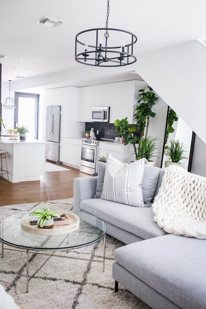 Foto di un piccolo soggiorno nordico stile loft con pareti bianche, pavimento in vinile, TV a parete e pavimento marrone