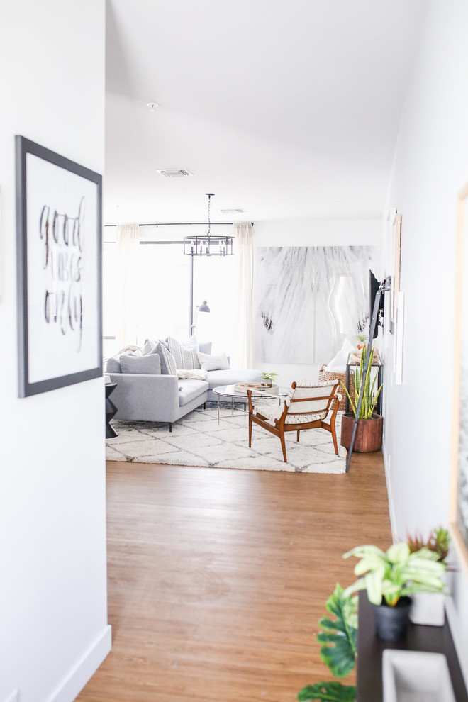 Kleines Nordisches Wohnzimmer im Loft-Stil mit weißer Wandfarbe, Vinylboden, TV-Wand und braunem Boden in Phoenix