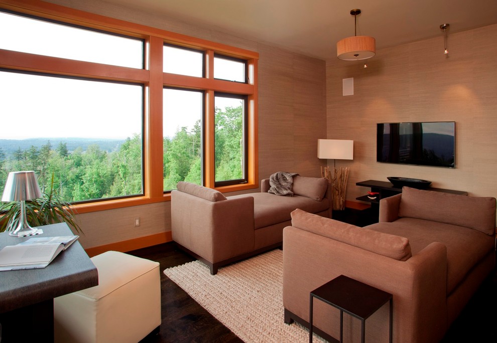 Immagine di un soggiorno minimal di medie dimensioni e aperto con libreria, pareti beige, parquet scuro e TV a parete