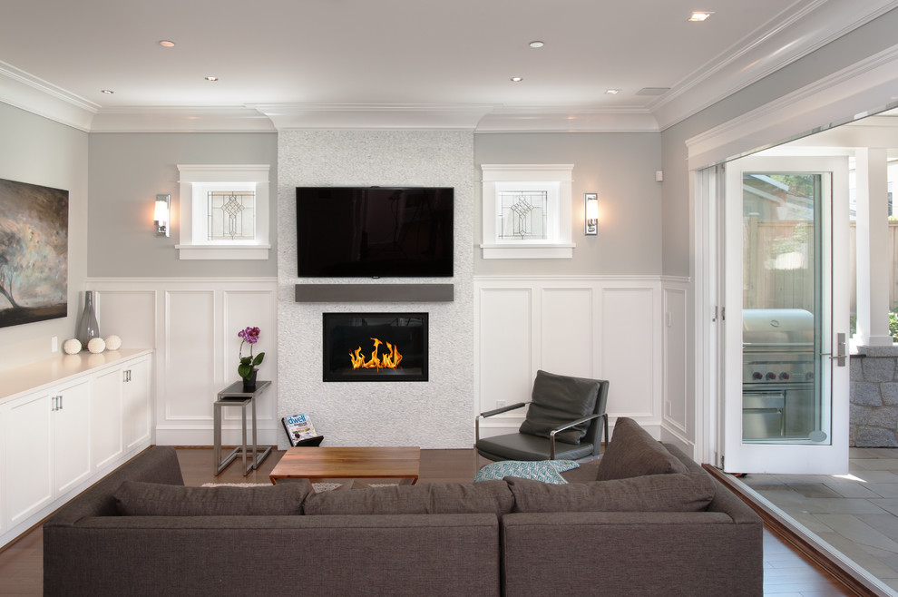 Inspiration for a mid-sized craftsman open concept medium tone wood floor family room remodel in Vancouver with gray walls, a standard fireplace, a tile fireplace and a wall-mounted tv
