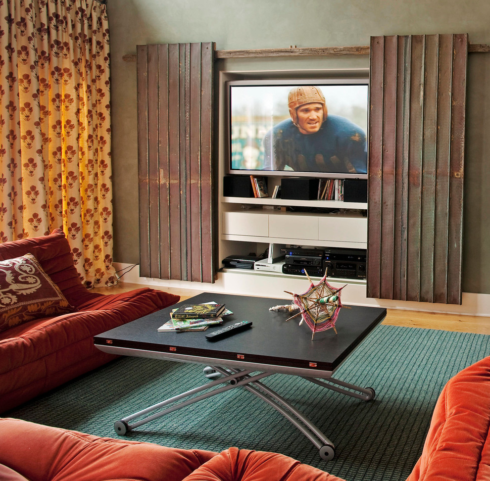 Foto di un grande soggiorno eclettico con TV nascosta, pareti verdi, parquet chiaro, nessun camino e pavimento arancione