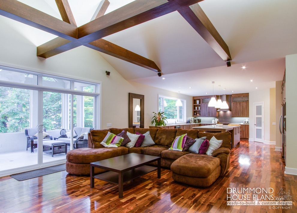Foto de sala de estar abierta de estilo americano grande sin chimenea con paredes blancas y suelo de madera en tonos medios