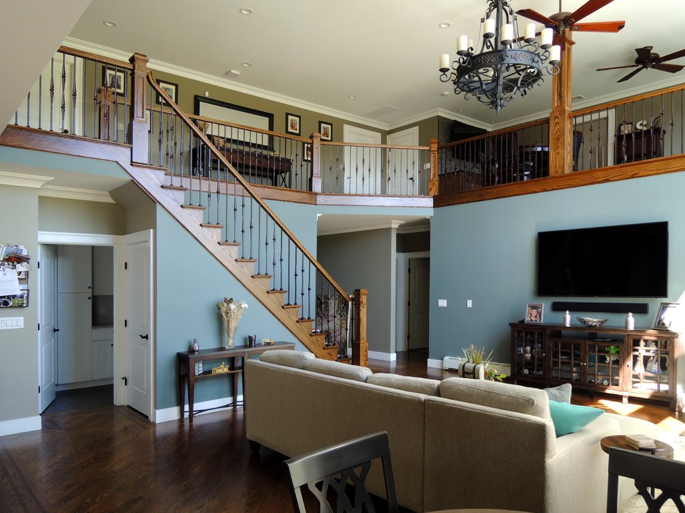 Exempel på ett stort amerikanskt allrum med öppen planlösning, med blå väggar, mörkt trägolv, en väggmonterad TV och brunt golv