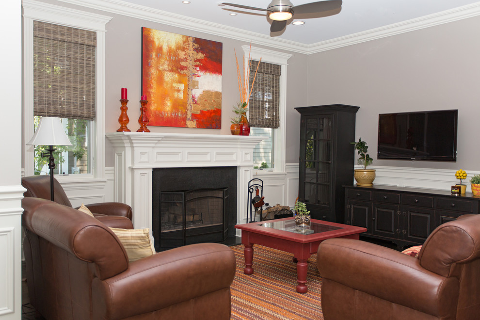 Esempio di un soggiorno classico di medie dimensioni con pareti grigie, camino classico, cornice del camino in legno e TV a parete
