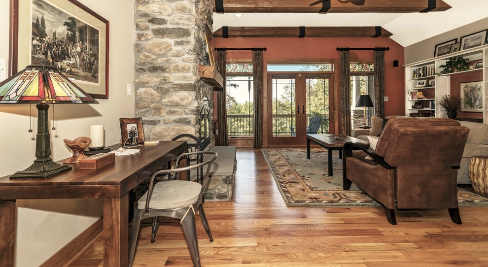 Exemple d'une grande salle de séjour craftsman ouverte avec un mur multicolore, parquet clair, une cheminée standard, un manteau de cheminée en pierre et un téléviseur indépendant.