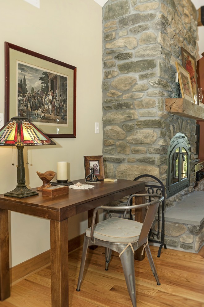 Cette image montre une grande salle de séjour craftsman ouverte avec un mur multicolore, parquet clair, une cheminée standard, un manteau de cheminée en pierre et un téléviseur indépendant.
