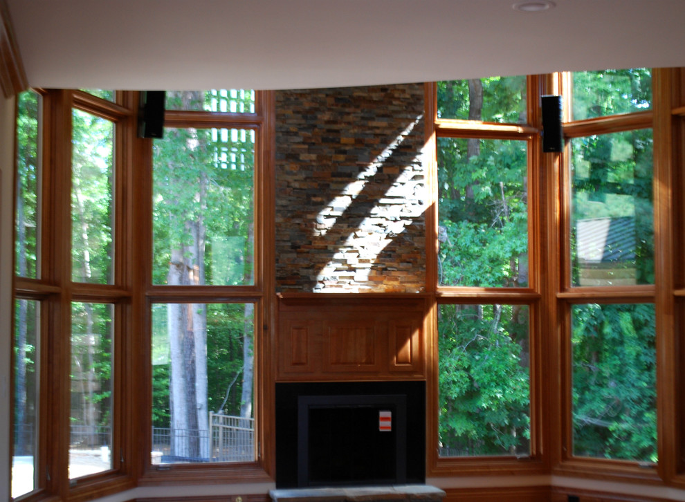 Geräumiges, Offenes Rustikales Wohnzimmer mit braunem Holzboden, Kamin und Kaminumrandung aus Stein in Raleigh