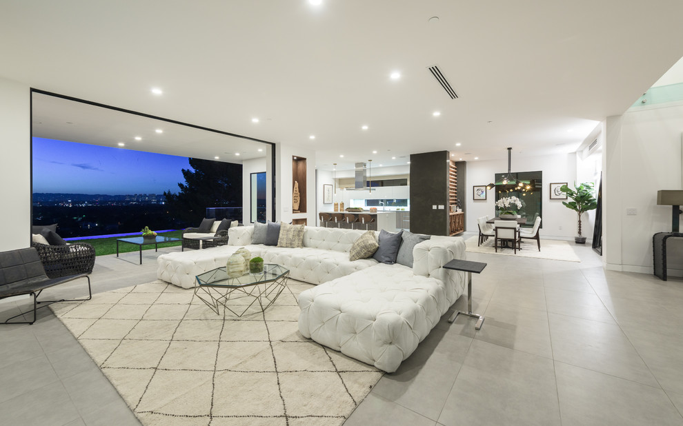 Immagine di un ampio soggiorno minimalista aperto con pareti bianche, pavimento in cemento, camino lineare Ribbon e TV a parete