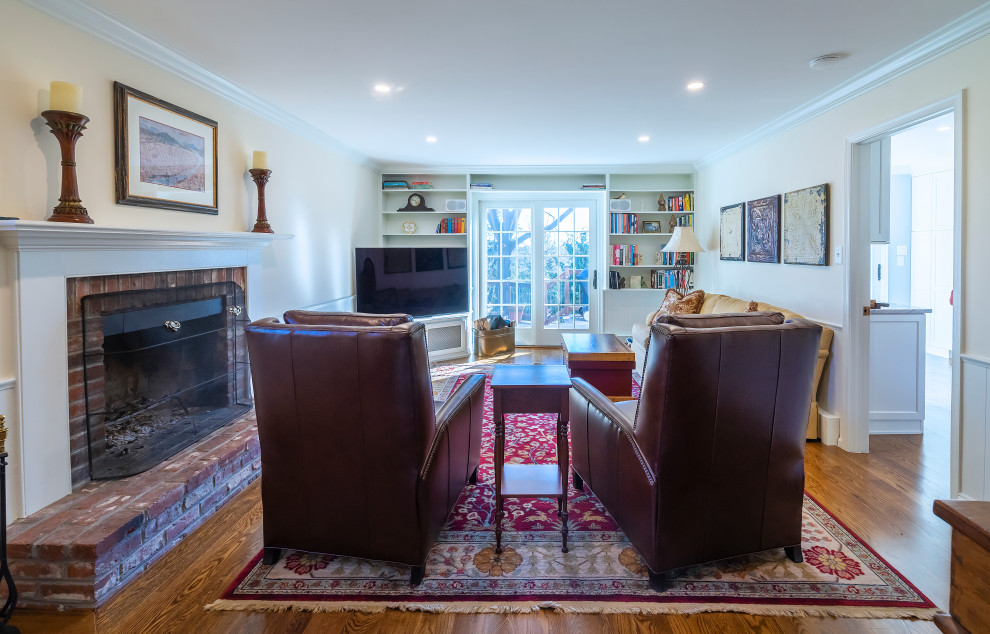 Photo of a small traditional enclosed games room in Philadelphia with beige walls, medium hardwood flooring, a standard fireplace and a brick fireplace surround.