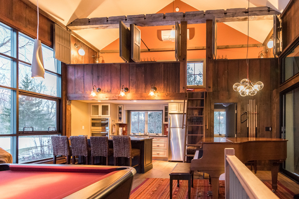 This is an example of a medium sized classic mezzanine games room in New York with a music area, orange walls, medium hardwood flooring, no fireplace, no tv and brown floors.