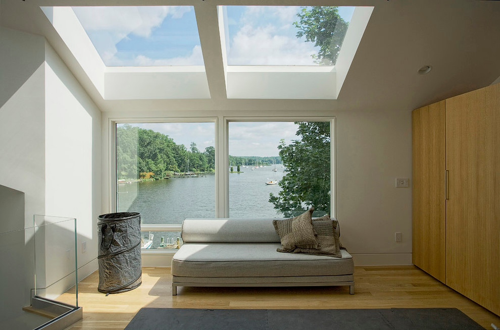 Пример оригинального дизайна: двухуровневая гостиная комната в современном стиле с белыми стенами и паркетным полом среднего тона