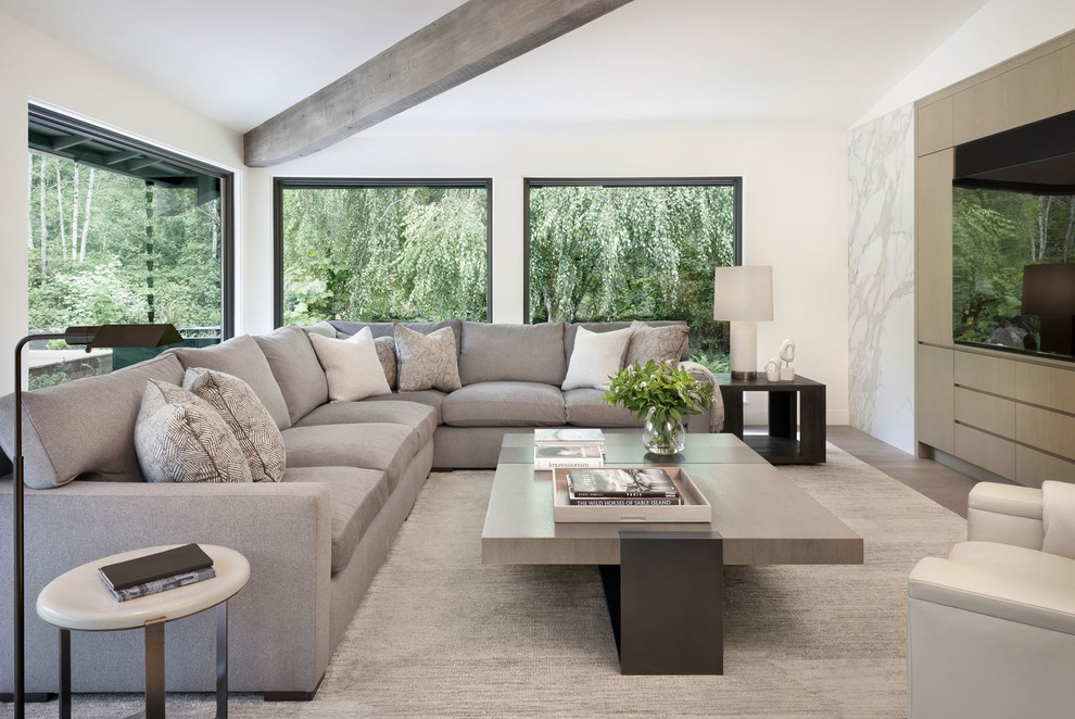 Immagine di un soggiorno design con pareti bianche, pavimento in legno massello medio, parete attrezzata e pavimento marrone