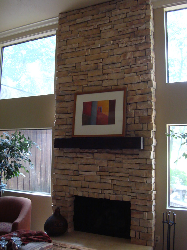 Modernes Wohnzimmer mit brauner Wandfarbe, Kamin und Kaminumrandung aus Stein in Houston