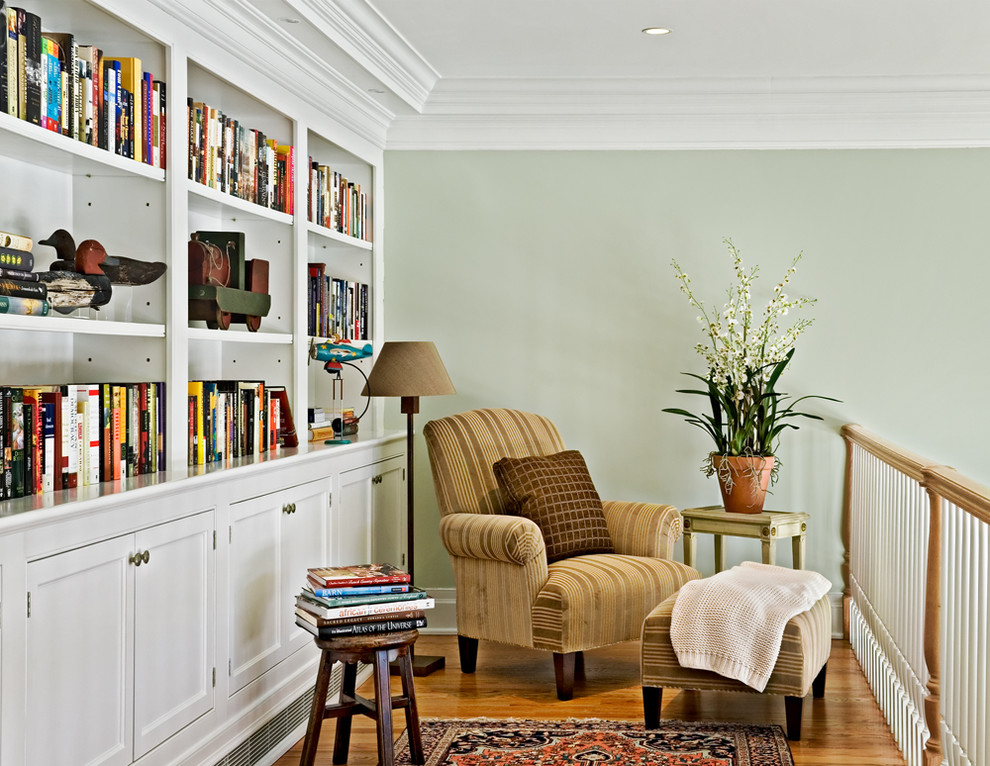 На фото: двухуровневая гостиная комната:: освещение в стиле кантри с зелеными стенами и с книжными шкафами и полками с