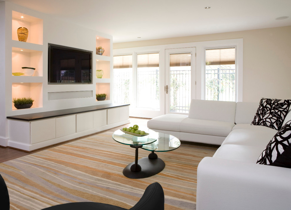 Modelo de sala de estar actual con paredes beige, pared multimedia y alfombra