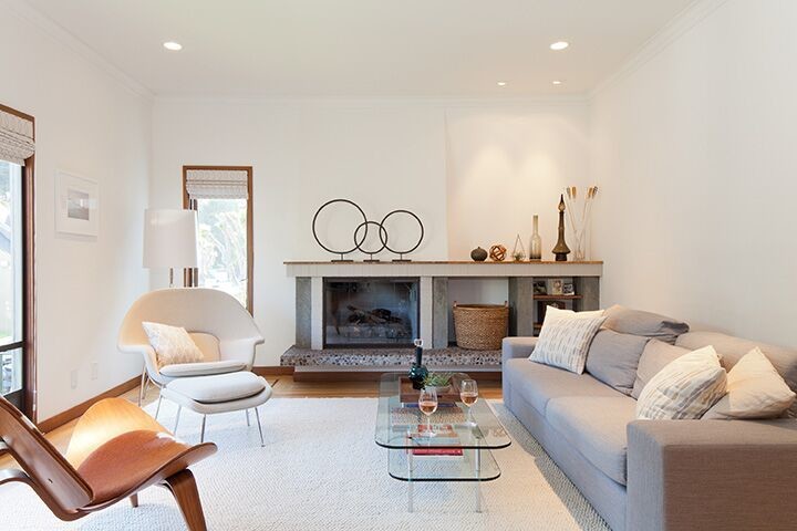Immagine di un soggiorno moderno di medie dimensioni con pareti bianche, parquet chiaro, camino classico, nessuna TV e pavimento marrone