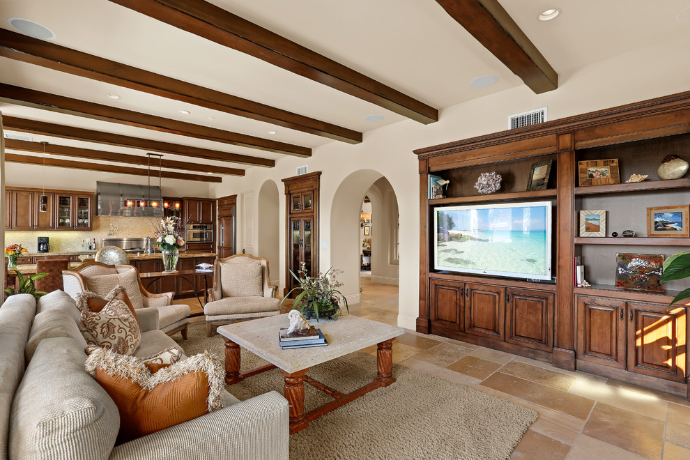 Inspiration for a large mediterranean open concept limestone floor and beige floor family room remodel in Orange County with beige walls, a standard fireplace, a stone fireplace and a media wall