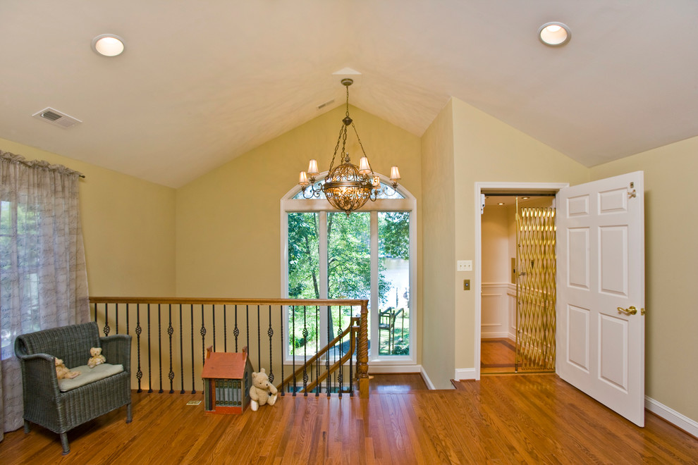 Immagine di un soggiorno chic di medie dimensioni e stile loft con pareti gialle, pavimento in legno massello medio, nessun camino e nessuna TV
