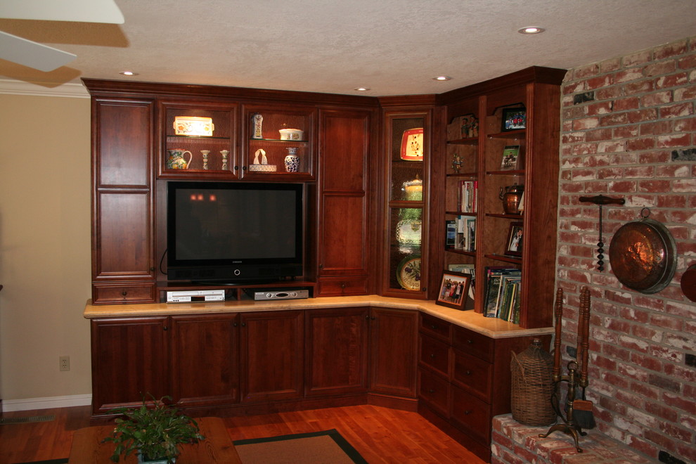 This is an example of a medium sized classic open plan games room in San Francisco with beige walls, medium hardwood flooring, a standard fireplace, a brick fireplace surround and a built-in media unit.