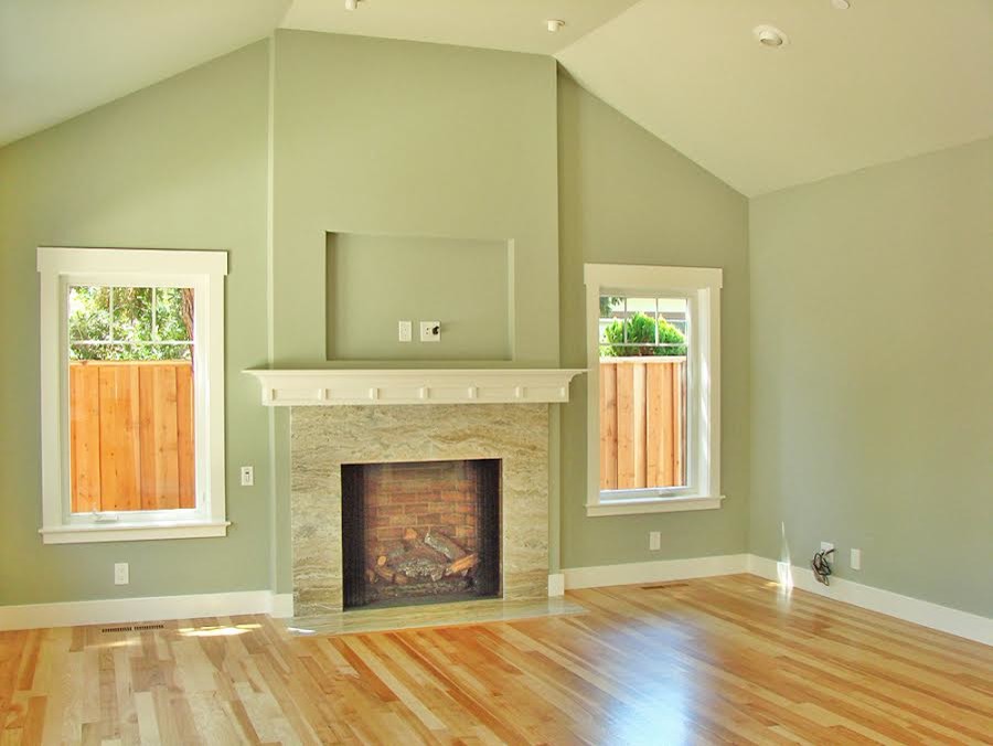 Idée de décoration pour une grande salle de séjour design ouverte avec un mur vert, un sol en bois brun, une cheminée standard et un manteau de cheminée en carrelage.