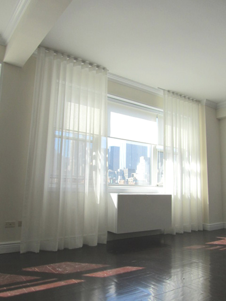 Idée de décoration pour une salle de séjour minimaliste de taille moyenne avec un mur blanc et un sol en bois brun.