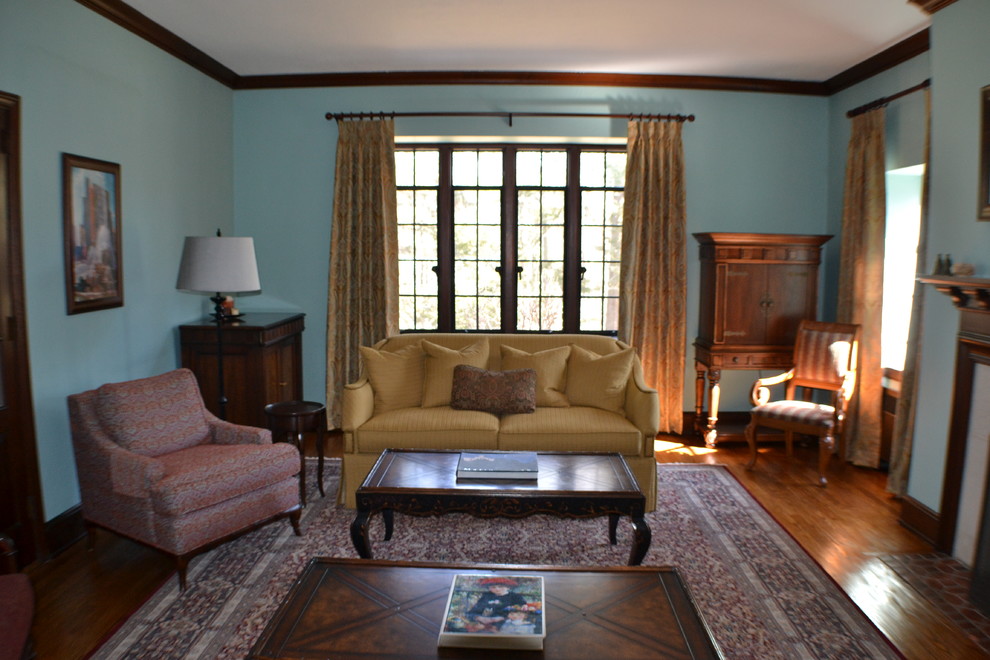На фото: большая открытая гостиная комната в классическом стиле с зелеными стенами, паркетным полом среднего тона, стандартным камином и фасадом камина из камня без телевизора с