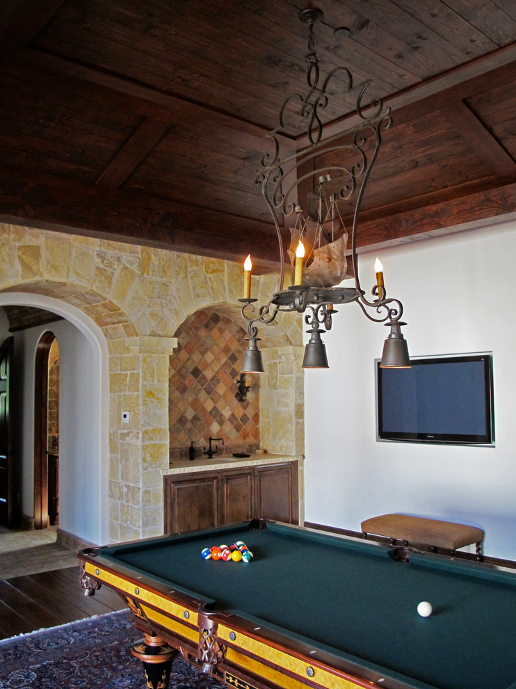 Ejemplo de sala de juegos en casa cerrada rural grande sin chimenea con paredes blancas, suelo de madera oscura, televisor colgado en la pared y suelo marrón