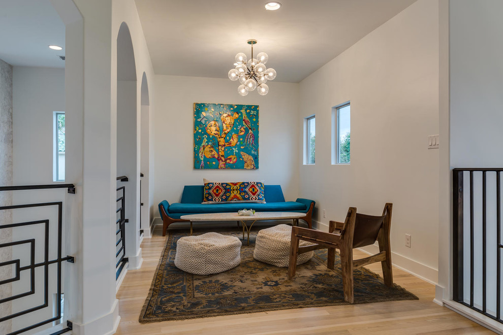 Ejemplo de sala de estar abierta contemporánea pequeña sin chimenea y televisor con paredes blancas, suelo de madera clara y suelo marrón