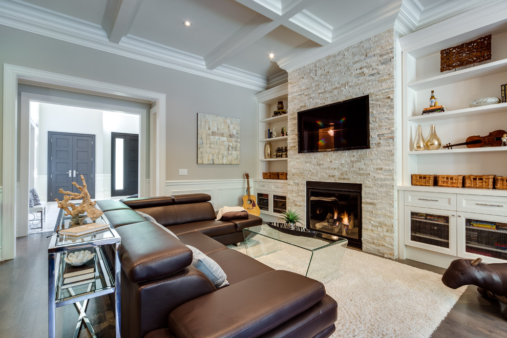 Inspiration for a large contemporary open plan games room in Toronto with beige walls, medium hardwood flooring, a standard fireplace, a stone fireplace surround, a wall mounted tv and brown floors.