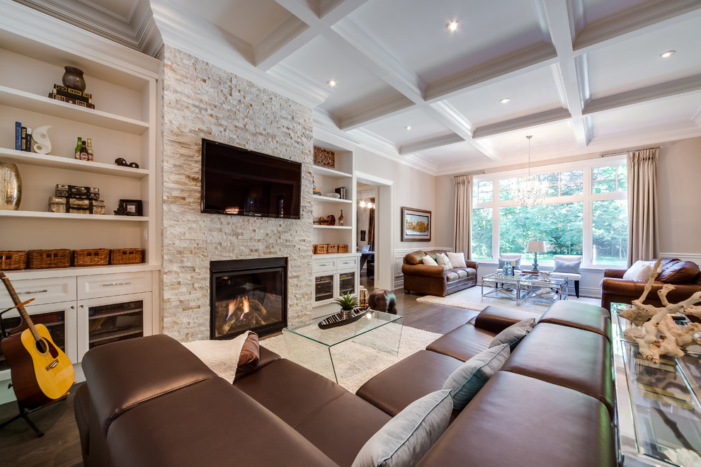 Großes, Offenes Klassisches Wohnzimmer mit Kaminumrandung aus Stein, beiger Wandfarbe, braunem Holzboden, Kamin, TV-Wand und braunem Boden in Toronto