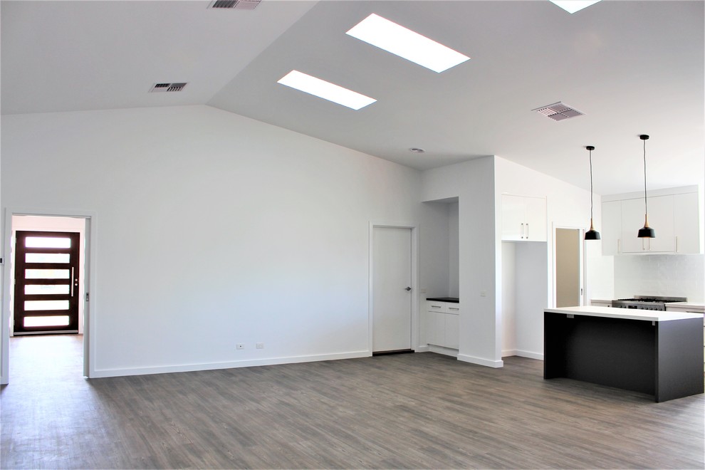 Exemple d'une grande salle de séjour tendance ouverte avec un mur blanc, un sol en linoléum et un sol gris.