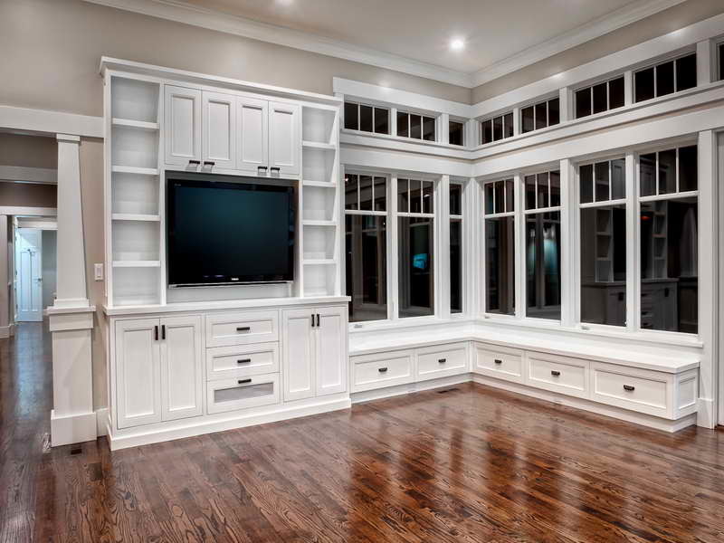 Exempel på ett mellanstort klassiskt allrum, med grå väggar, mörkt trägolv, en väggmonterad TV och brunt golv