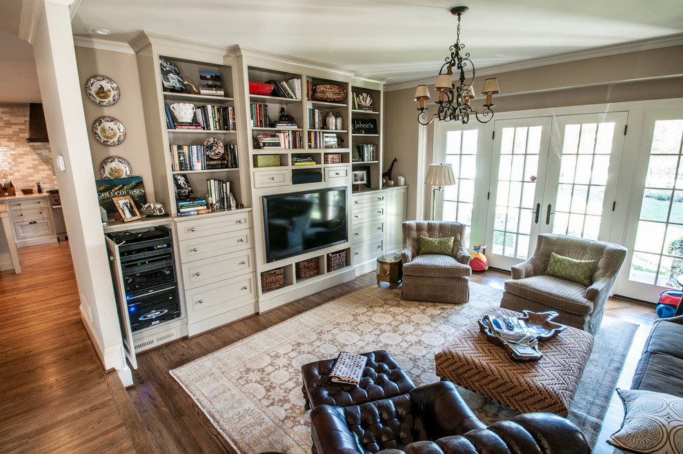 This is an example of a medium sized world-inspired open plan games room in Charlotte with a built-in media unit, beige walls, light hardwood flooring and no fireplace.