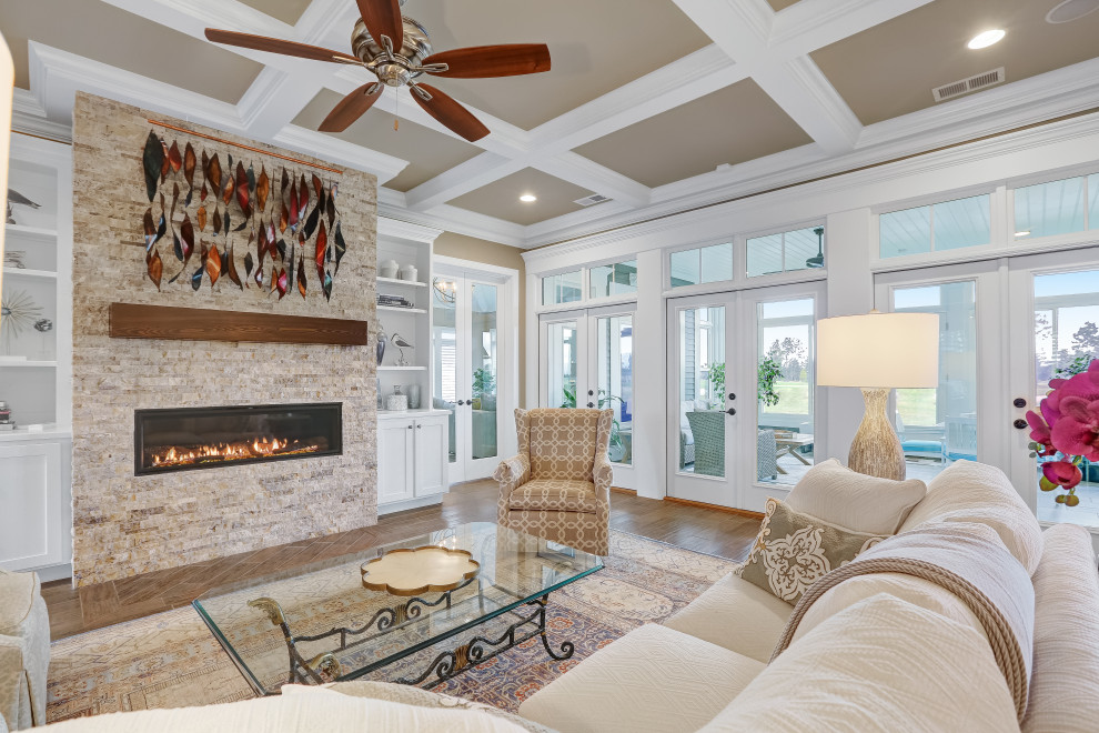 This is an example of a medium sized nautical open plan games room in Wilmington with beige walls, ceramic flooring, a two-sided fireplace, a stone fireplace surround, no tv and brown floors.