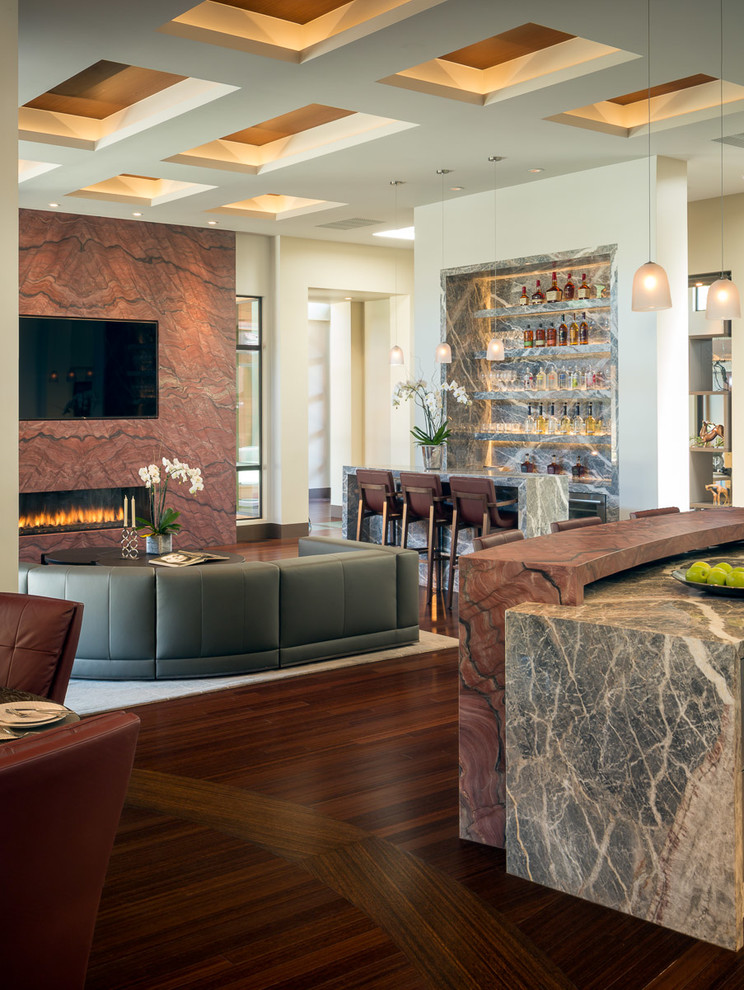 Large contemporary open plan games room in San Francisco with a home bar, beige walls, a ribbon fireplace, a stone fireplace surround, a wall mounted tv and dark hardwood flooring.
