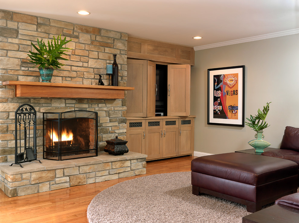 Cette image montre une salle de séjour traditionnelle de taille moyenne et ouverte avec un sol en bois brun, une cheminée standard, un manteau de cheminée en pierre et un téléviseur dissimulé.