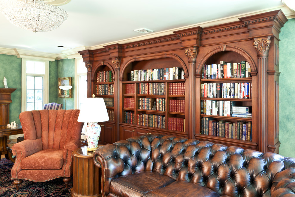На фото: большая открытая гостиная комната в классическом стиле с с книжными шкафами и полками, зелеными стенами, полом из ламината и желтым полом с