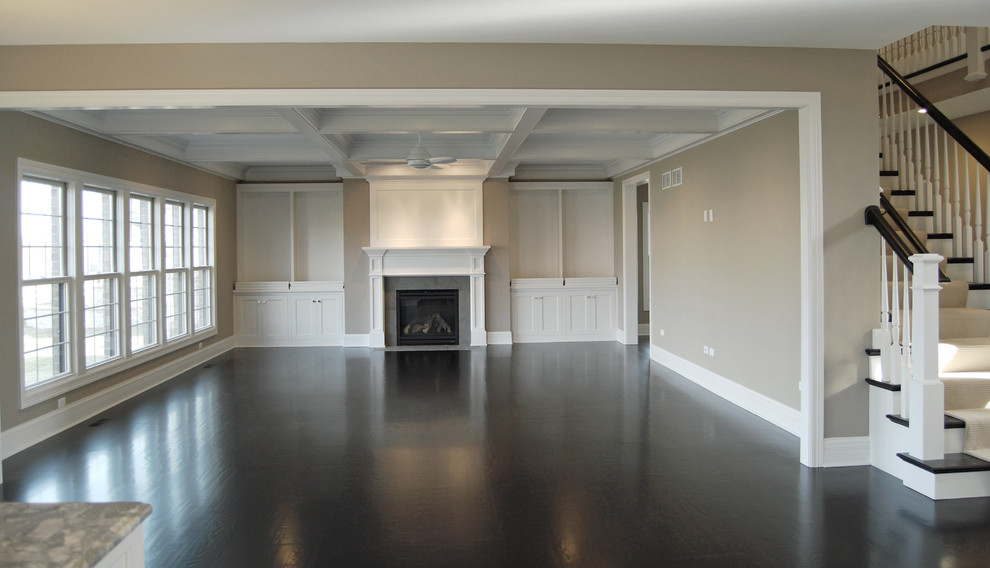 Large elegant open concept dark wood floor family room photo in Chicago with a standard fireplace, a wood fireplace surround, beige walls and no tv