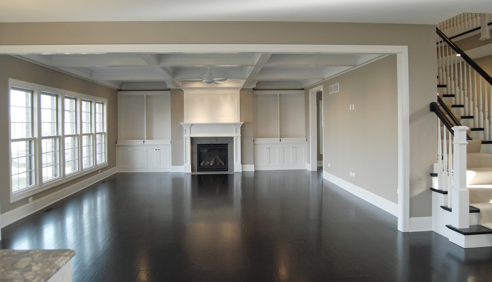 Inspiration for a large classic open plan games room in Chicago with a standard fireplace, a wooden fireplace surround, beige walls, dark hardwood flooring and no tv.