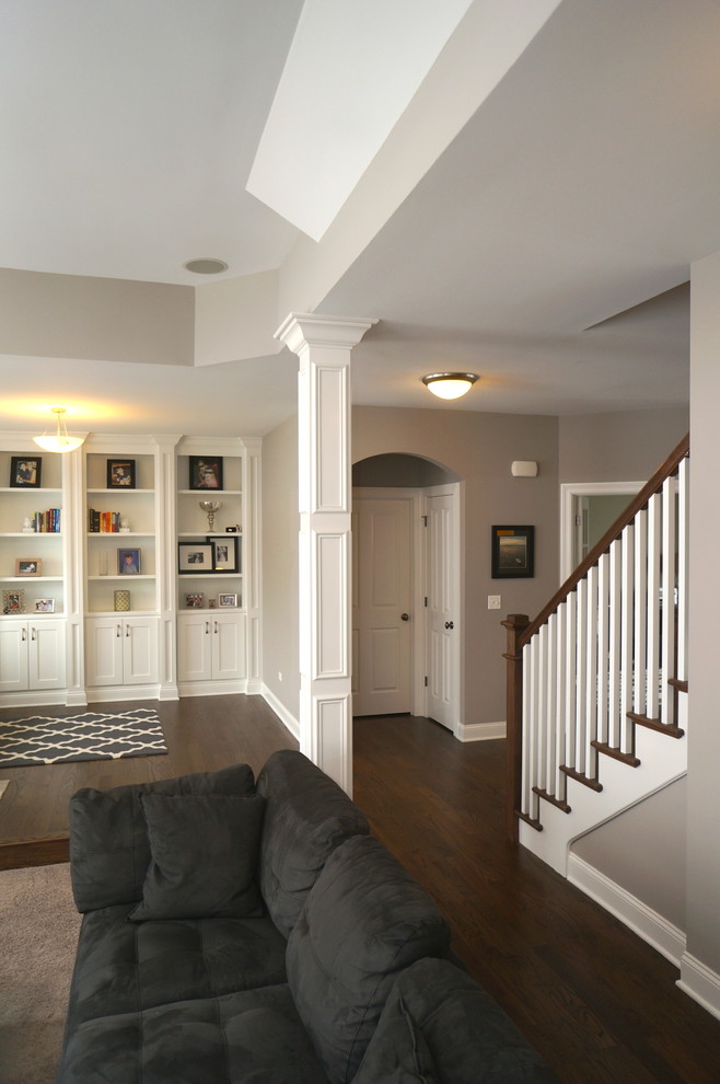 Exemple d'une grande salle de séjour craftsman ouverte avec une bibliothèque ou un coin lecture, un mur gris, moquette et un téléviseur encastré.