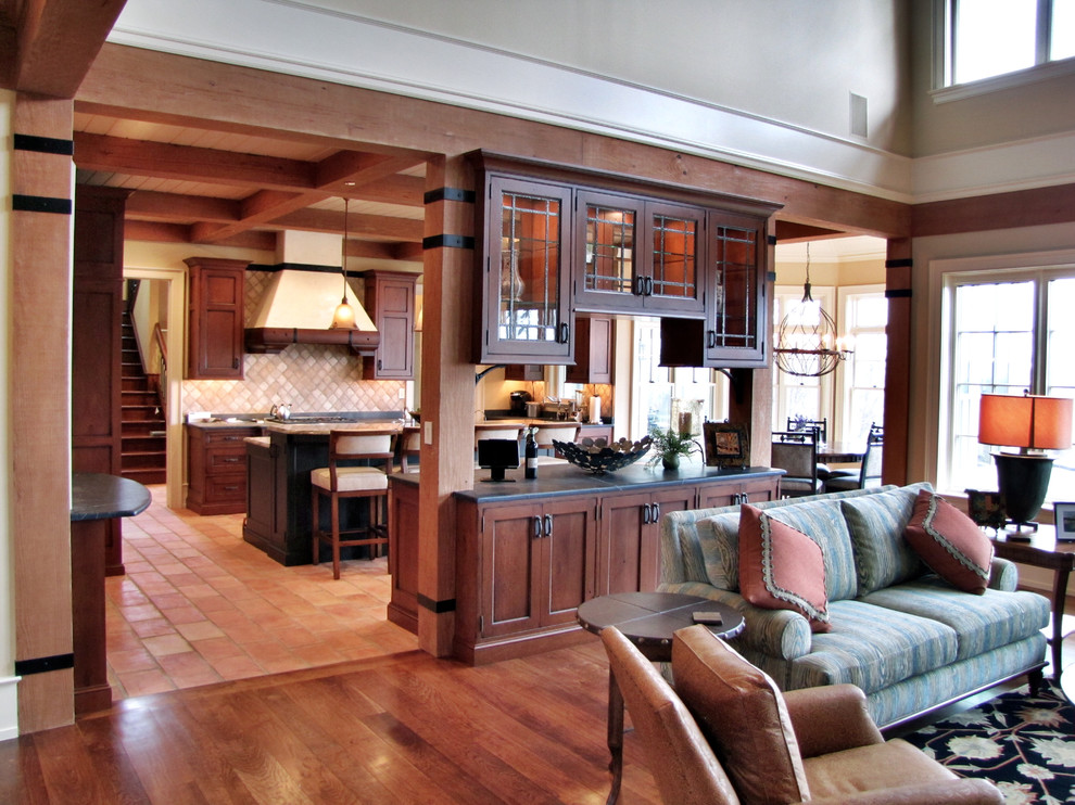 Imagen de sala de estar abierta de estilo americano con paredes beige, suelo de madera en tonos medios, todas las chimeneas, marco de chimenea de piedra y televisor retractable