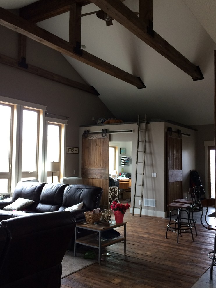 Ejemplo de sala de estar abierta de estilo americano de tamaño medio con paredes grises y suelo de madera oscura