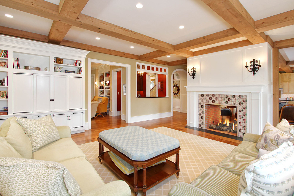 Design ideas for a traditional open plan living room in Philadelphia with beige walls, medium hardwood flooring, a two-sided fireplace, a tiled fireplace surround and a concealed tv.