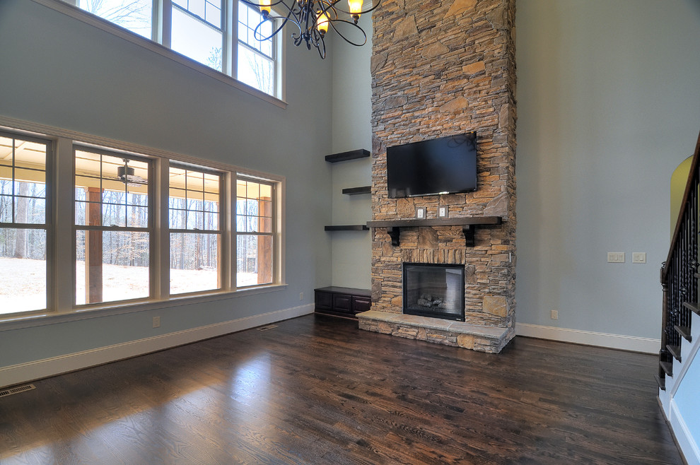Photo of an expansive classic open plan games room in Charlotte with blue walls, dark hardwood flooring, a stone fireplace surround and a wall mounted tv.